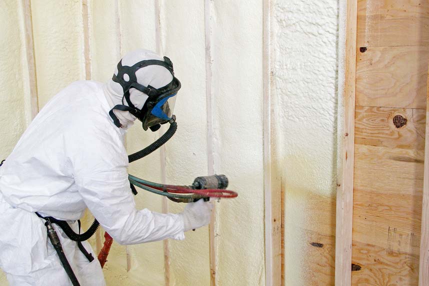 Spray foam insulation installer, insulating closed-cell-spray foam, in new built home's walls.