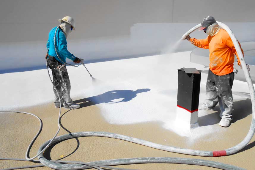 Spray foam insulation installers, insulating building's flat roof.