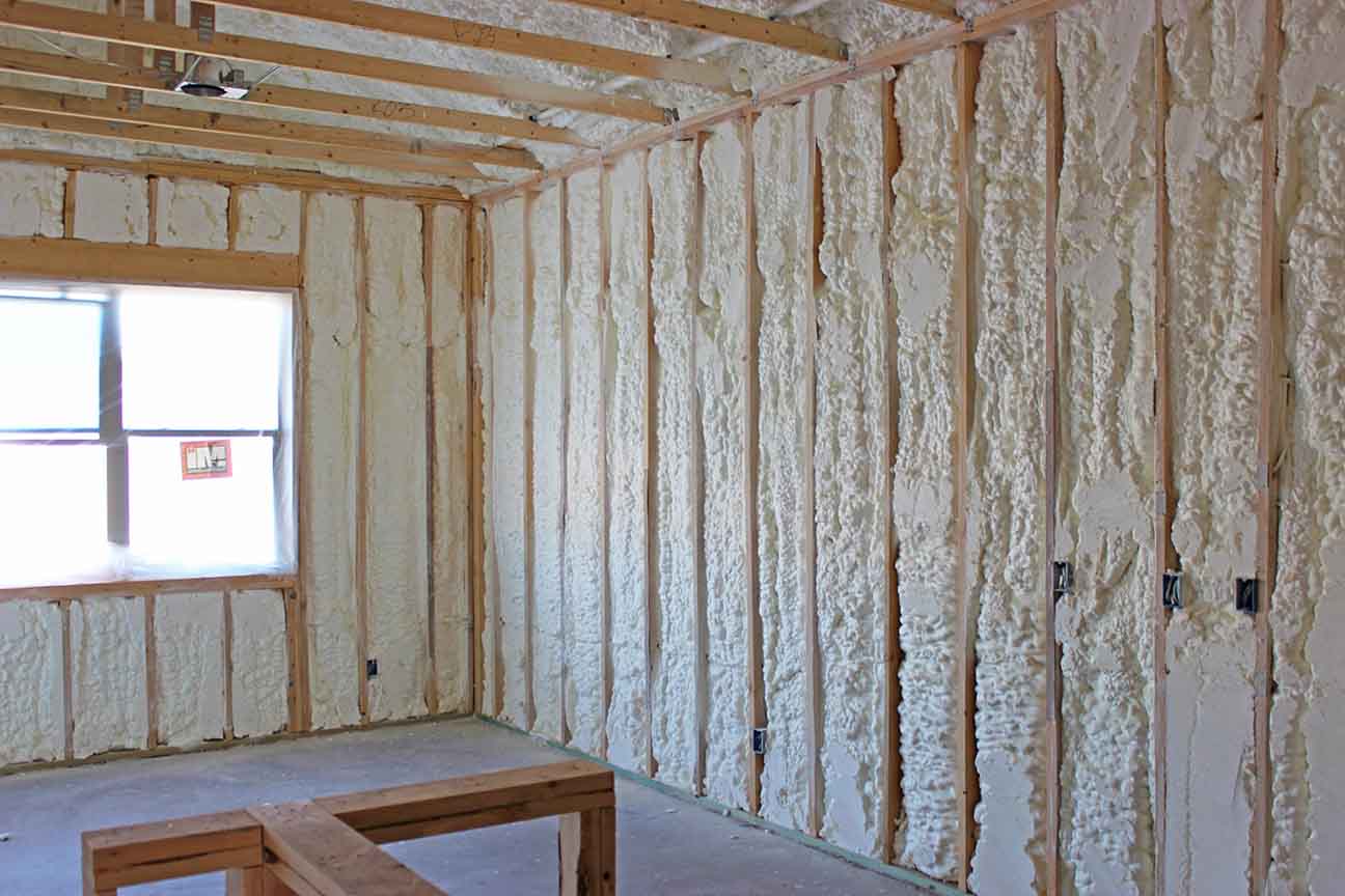 Interior residential walls fully insulated with Quik-Shield Dragon XL closed-cell spray foam, providing airtight and energy-efficient coverage.